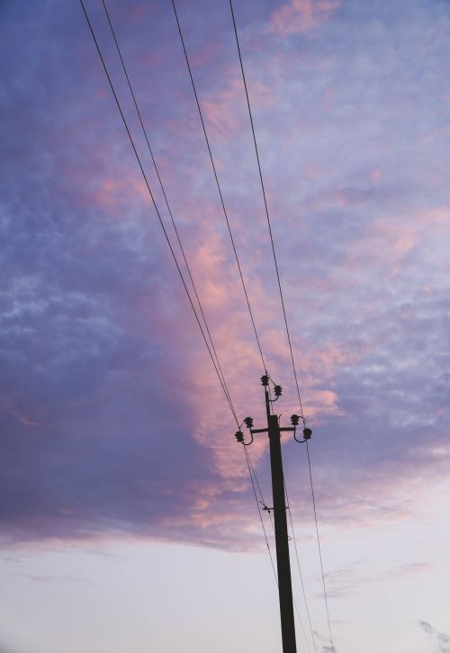Free High voltage power lines silhouetted against a colorful sunset sky. Stock Photo