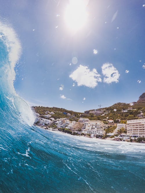 Fotografia De Closeup De Onda Do Mar Perto De Um Edifício De Concreto Durante O Dia