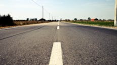 在意大利里诺卡尔德龙，一条宁静的乡村道路旁，蔚蓝的天空下是开阔的田野