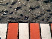 在阳光明媚的日子里，希腊圣托里尼岛的黑色沙滩和色彩缤纷的小路非常适合拍摄