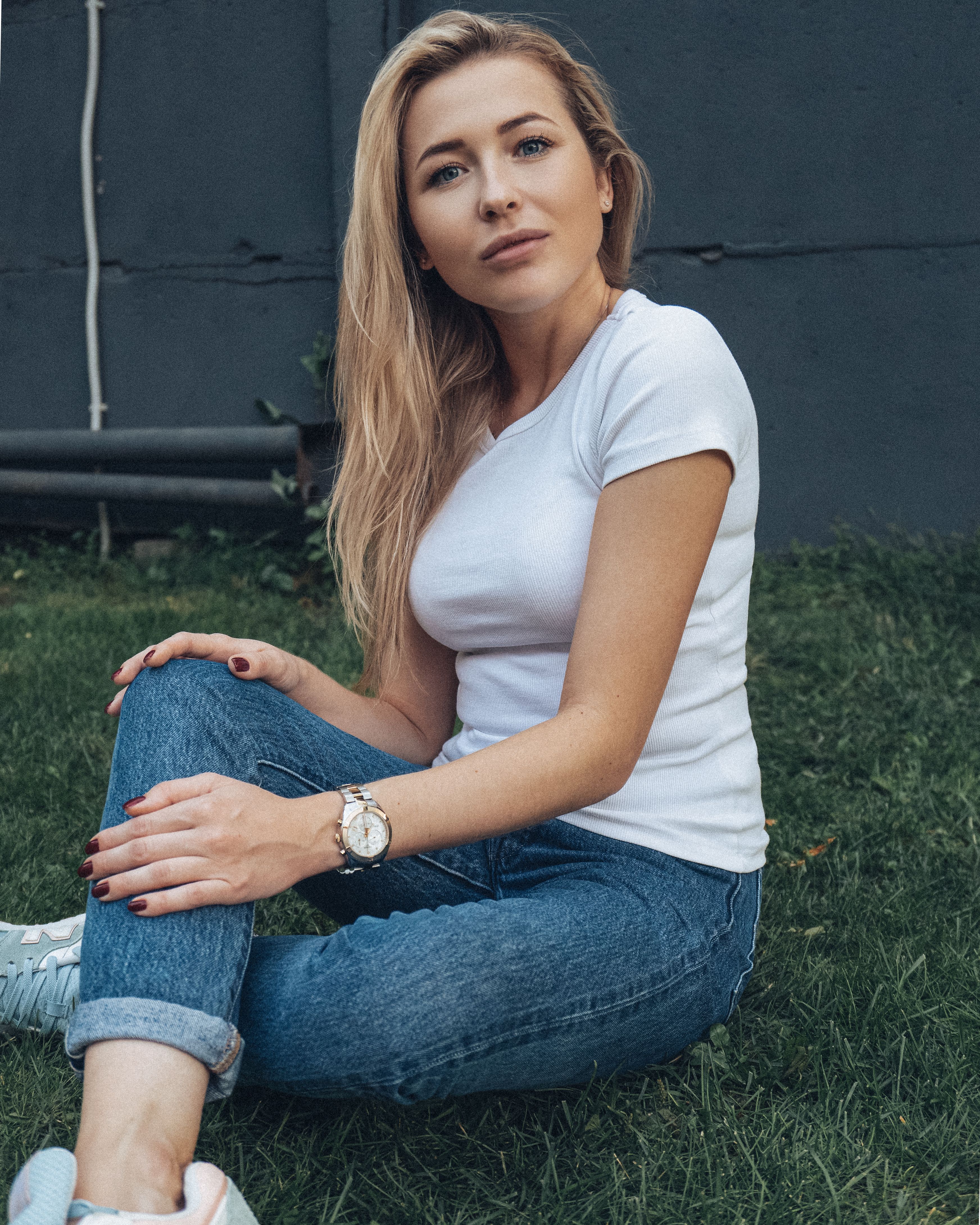 A Woman in White Shirt and Blue Jeans Sitting on a Grass · Free Stock Photo