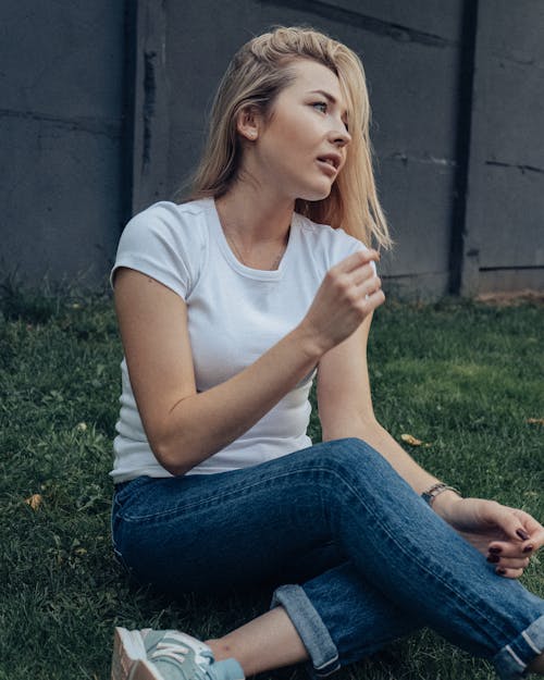 A Blonde Woman Wearing a White Shirt and Denim Jeans