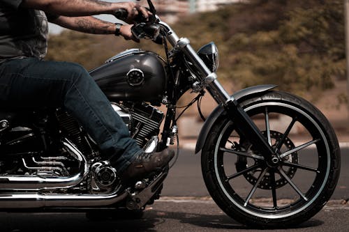 Free Person in Blue Denim Jeans Sitting on Black Motorcycle Stock Photo