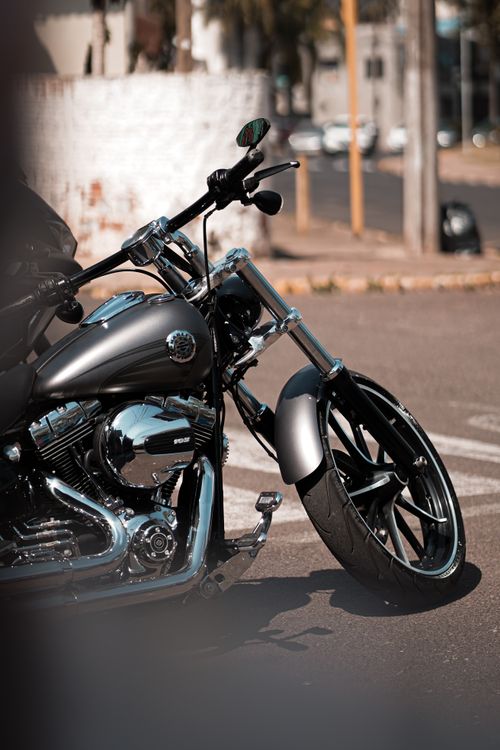 Free Close-up view of a parked black motorcycle in an urban setting, showcasing its shiny details and modern design. Stock Photo