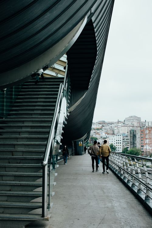 Free People walking on a modern urban walkway with architectural details and cityscape view. Stock Photo