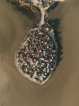 Drone view of a coastal community on a small peninsula surrounded by sea.