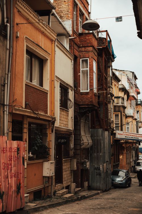 Free A quaint urban street lined with colorful historic buildings and rustic textures. Stock Photo
