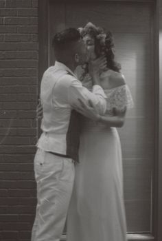 Elegant black and white photo of a couple sharing a romantic wedding kiss.