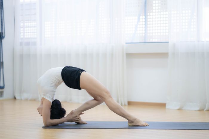 Woman lying on the floor on her back — knee-to-chest lumbar decompression stretch