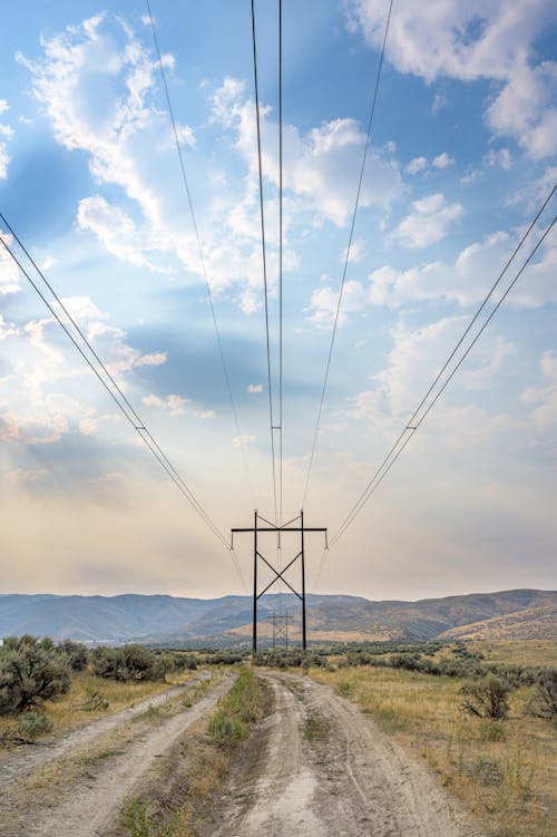 Foto d'estoc gratuïta de cables elèctrics, camí de carro, cel blau