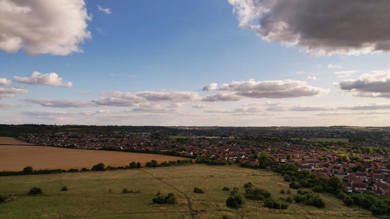 Aerial Shot of Cropland Beside the Houses 