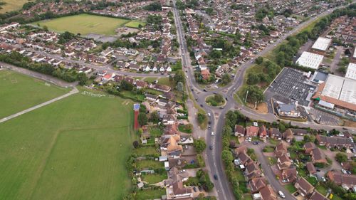 Free Drone shot of a suburban neighborhood and green fields in Luton, England. Stock Photo