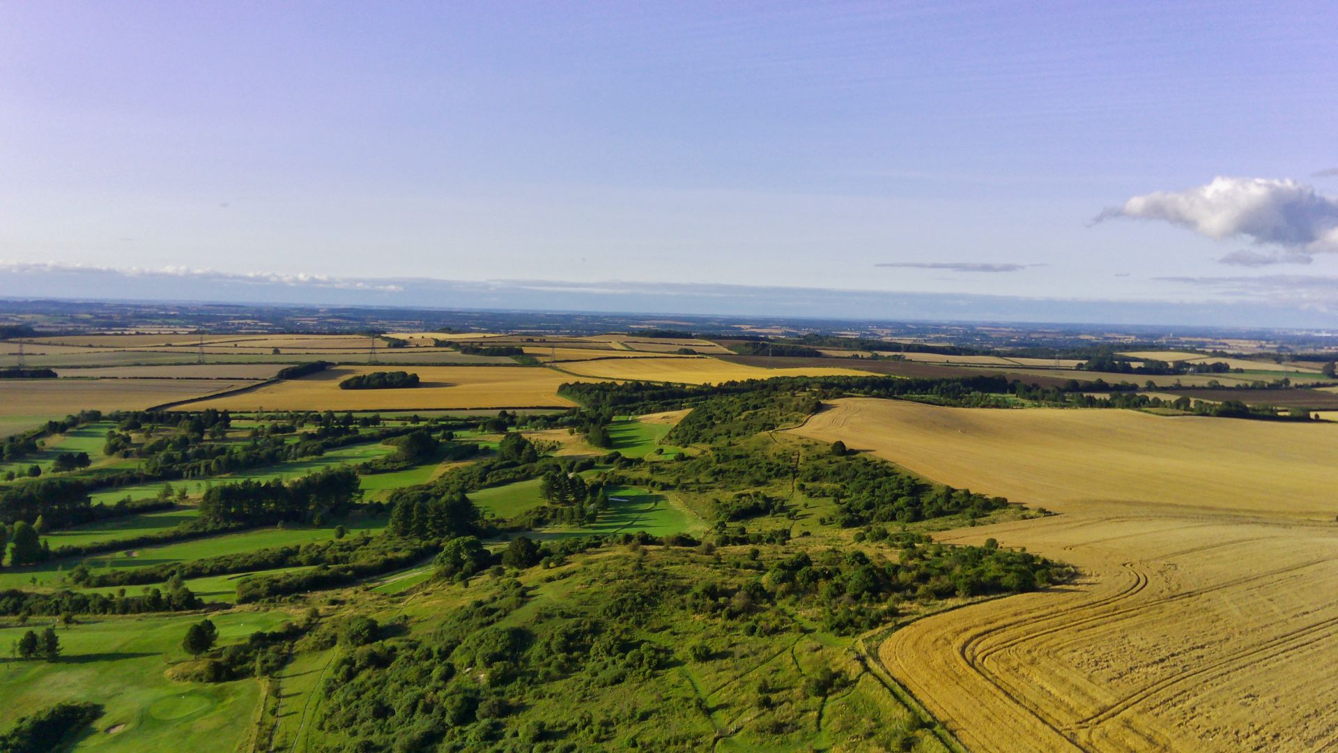 A stunning aerial view of the rural English countryside with fields and farmland on a clear day.