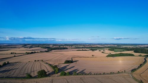 Free Aerial view of expansive farmland in Central Bedfordshire, UK, under a clear blue sky. Stock Photo