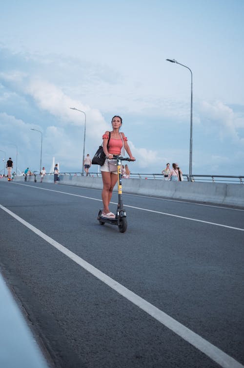 Free A Woman Riding an Electric Scooter Stock Photo