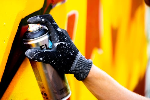 A Person with Black Gloves Holding a Spray Paint