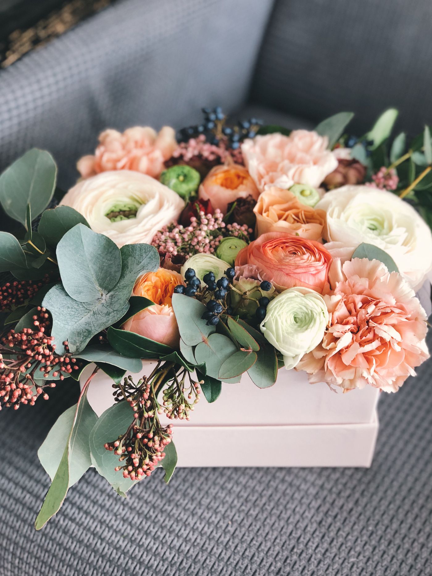 Peach ranunculus and eucalyptus box arrangement