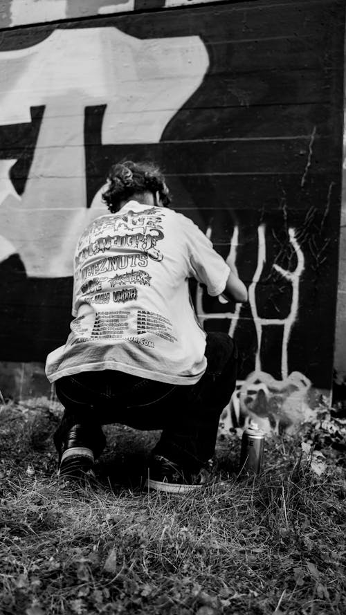 Back View of a Person Spray Painting a Wall