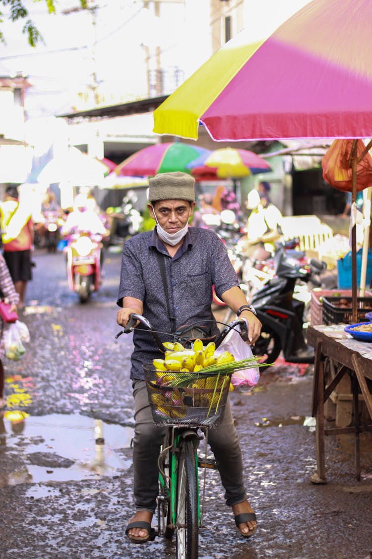 Man Riding A Bicycle With Bananas In A Basket