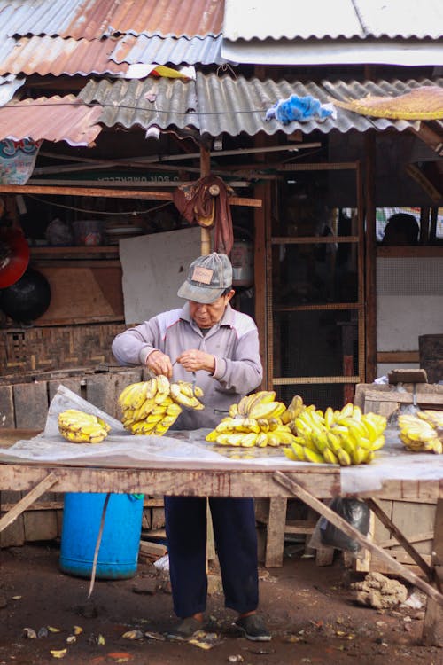 Безкоштовне стокове фото на тему «азіатський чоловік, банани, магазин»