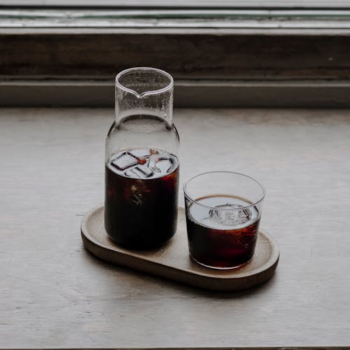 A Pitcher and Glass of Soda on a Wooden Tray