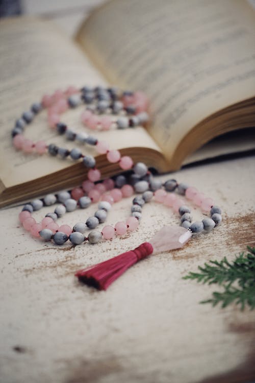Free White and Pink Beaded Necklace on Top of Open Book  Stock Photo