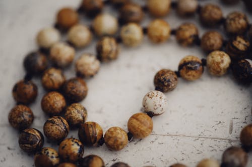 Free Close-Up Shot of Brown Round Beads on White Surface Stock Photo