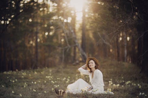 A Beautiful Woman in White Dress Sitting on Grass 