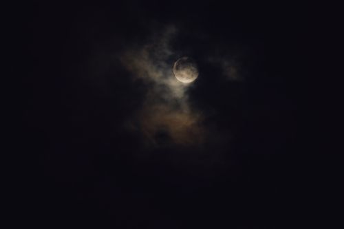 Free A dramatic depiction of the full moon veiled by clouds on a mysterious night. Stock Photo