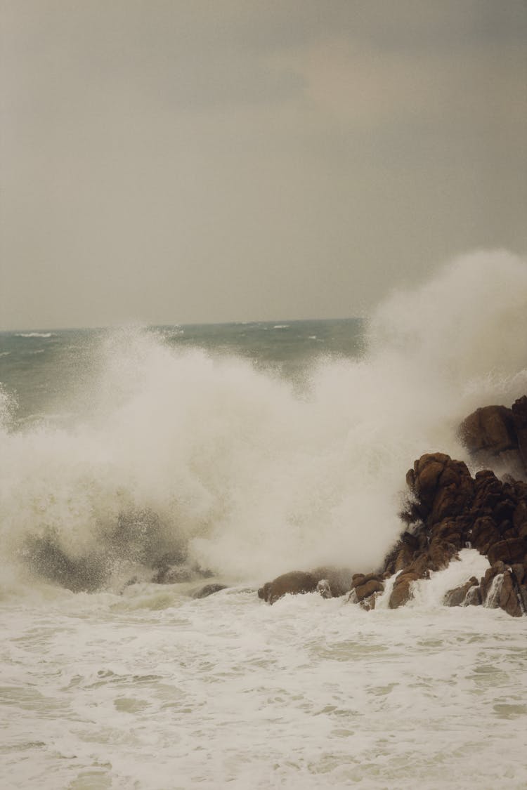 Ocean Waves Crashing On A Brown Rock