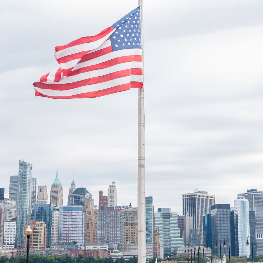 American flag with New York City skyline in the background