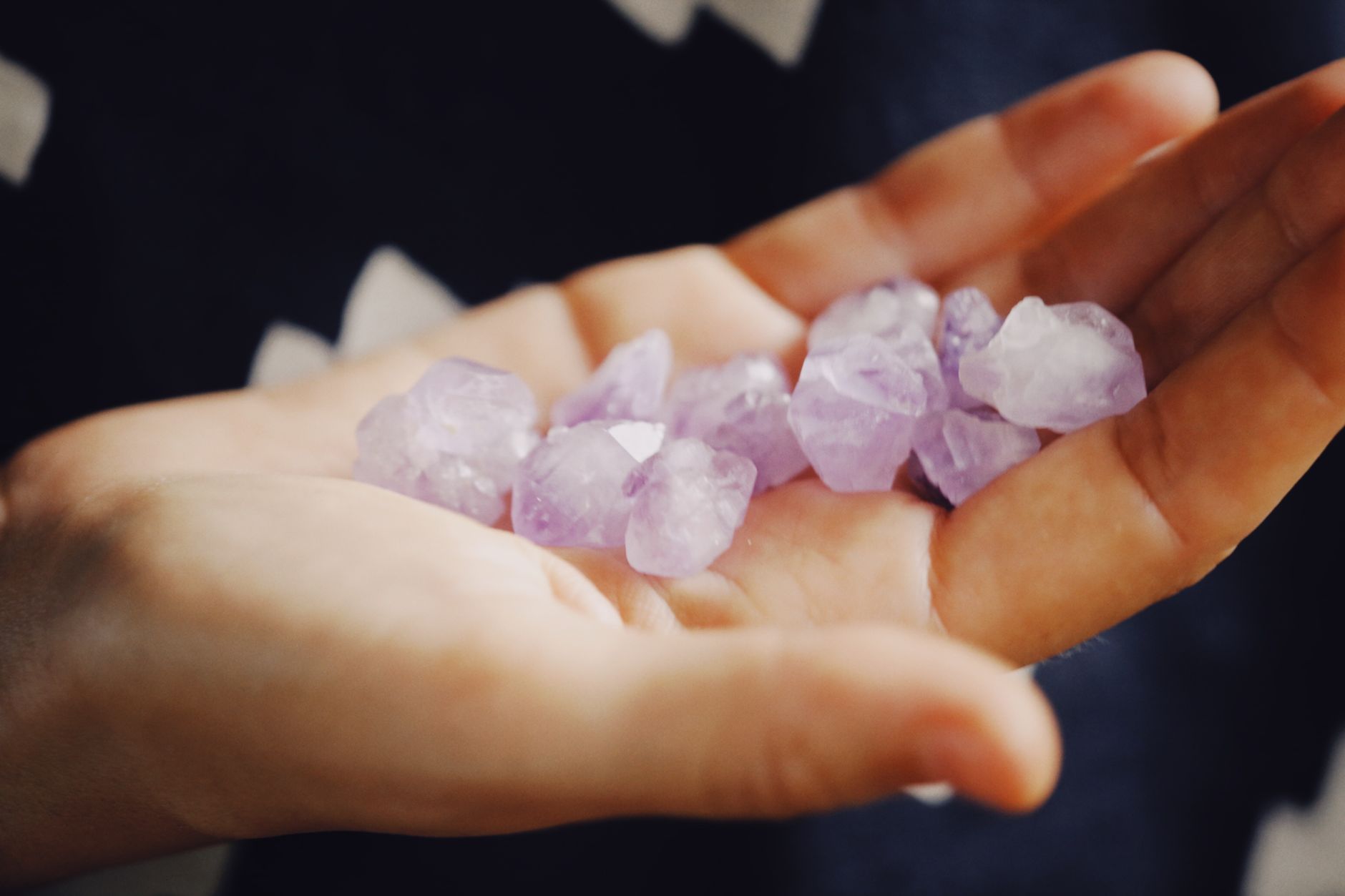 person choosing between different aries birthstone crystals and jewelry