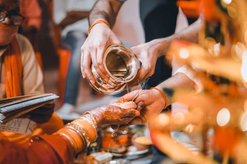 Free Close-up of traditional Indian wedding ritual pouring sacred water hands, highlighting cultural details. Stock Photo