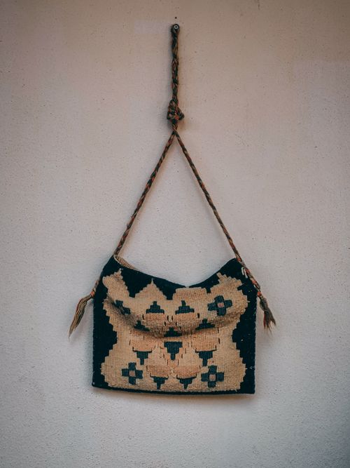 Free A crafted textile bag with geometric patterns hanging against a simple wall. Stock Photo
