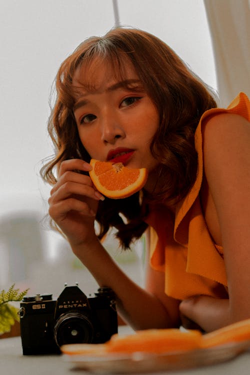 A Woman Holding a Slice Fruit