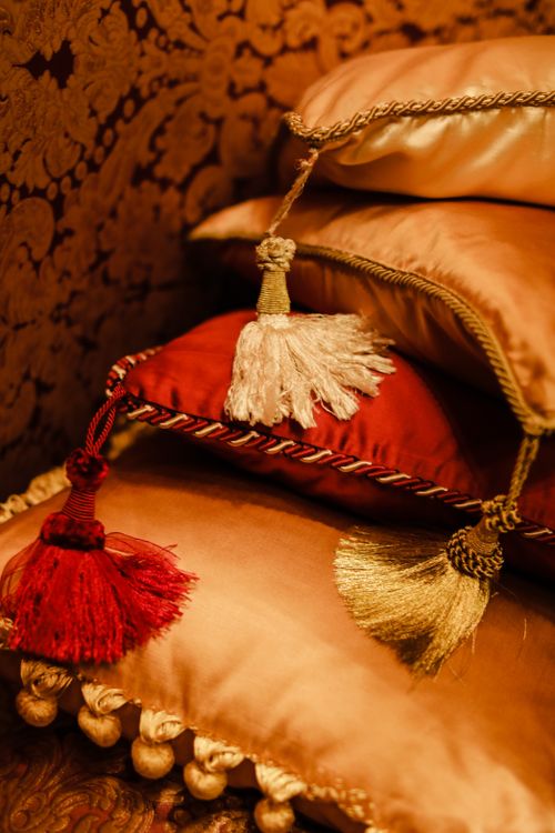 Free Luxurious throw pillows with tassels stacked in a warm, cozy setting. Stock Photo