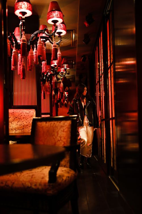 Free A young South Asian woman wearing a black leather jacket inside a cozy, dimly lit restaurant. Stock Photo