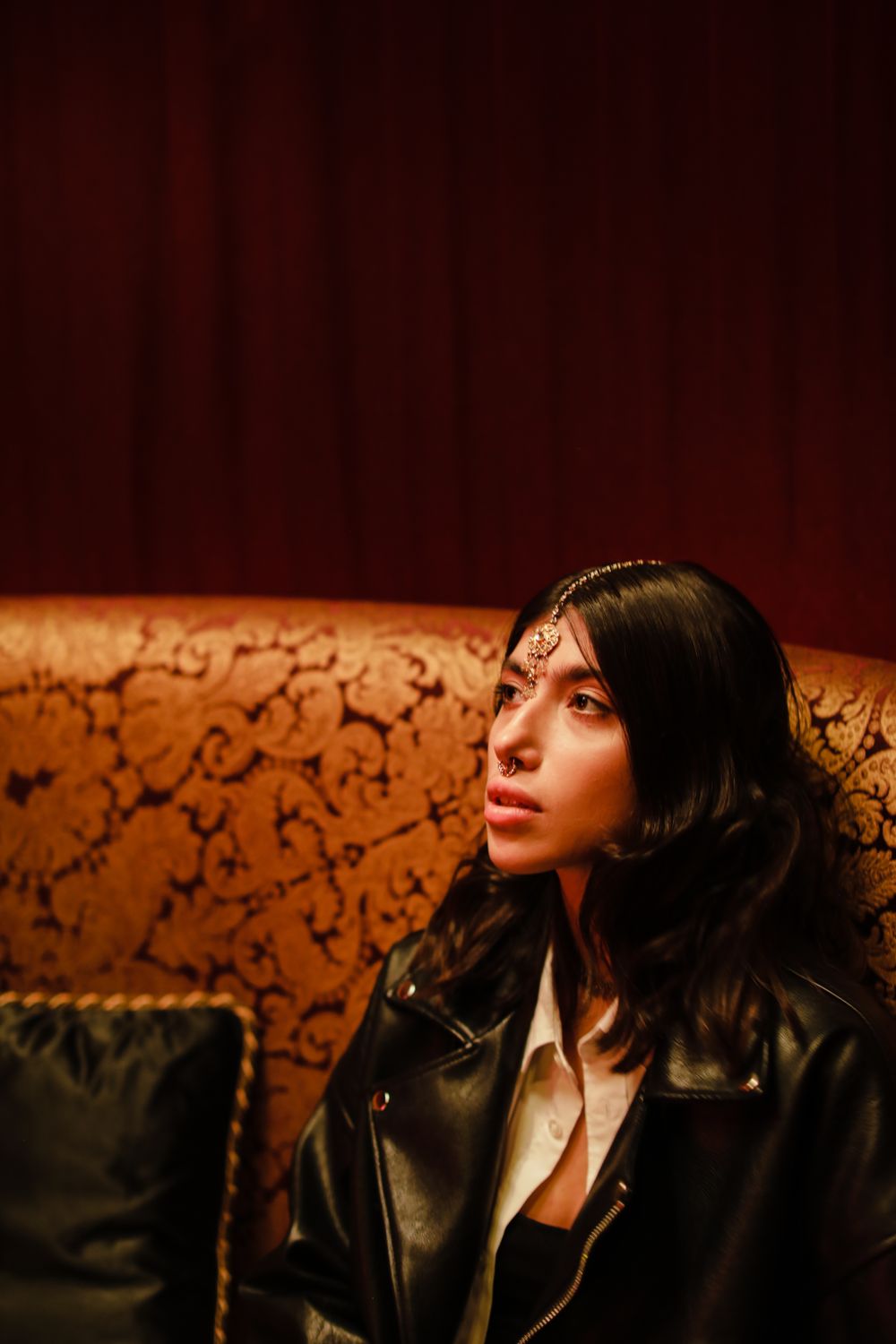 Woman in Black Leather Jacket Sitting on Brown Sofa · Free Stock Photo