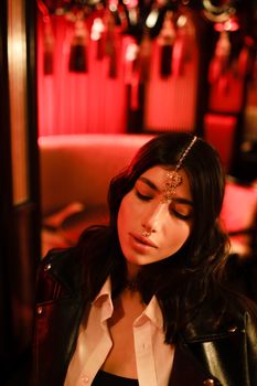 Woman Wearing Maang Tikka and Septum Piercing Posing Beautifully at the Camera while Looking Down
