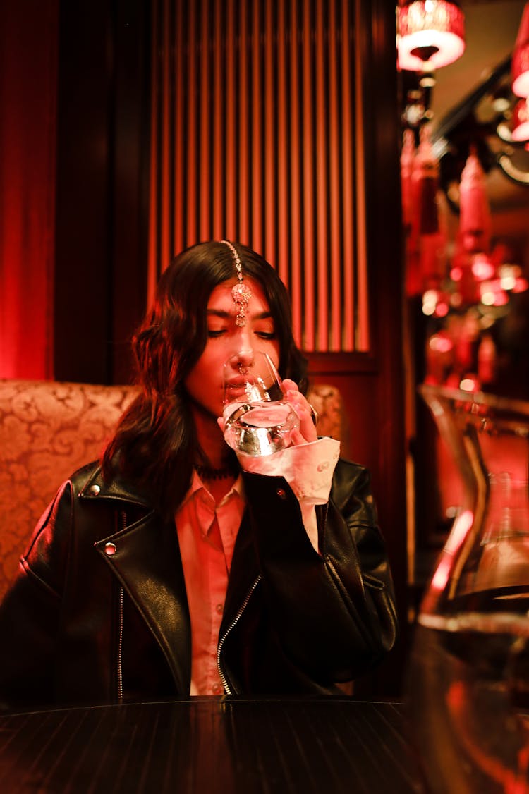 Woman In Black Leather Jacket Drinking Water From A Glass