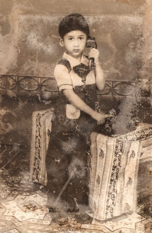 Free Old sepia photo of a young boy holding a telephone, classic and vintage feel. Stock Photo