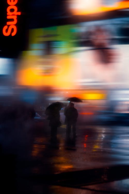 People Walking on the Wet Ground of a Street