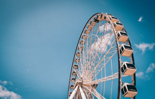 Free Upward view of a ferris wheel under a clear blue sky, a symbol of fun and adventure. Stock Photo