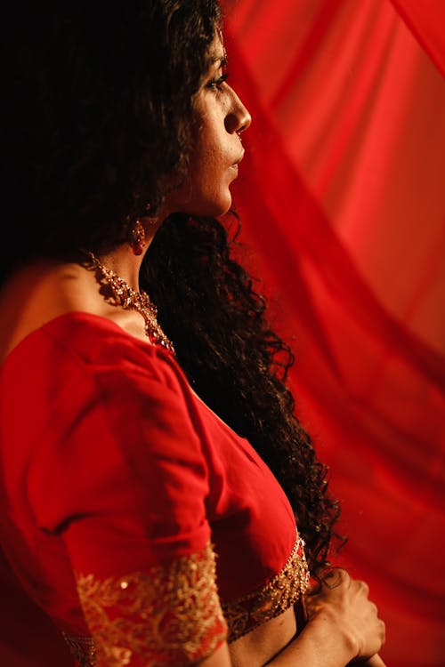 A Woman in Red Traditional Wear Looking Afar