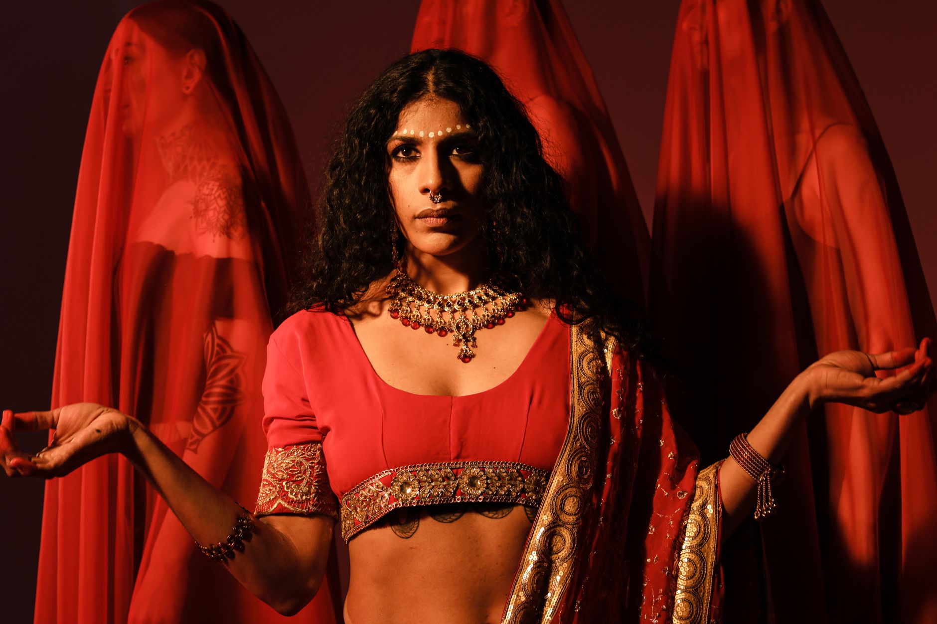 https://www.pexels.com/photo/woman-in-red-crop-top-against-veiled-women-9317201/