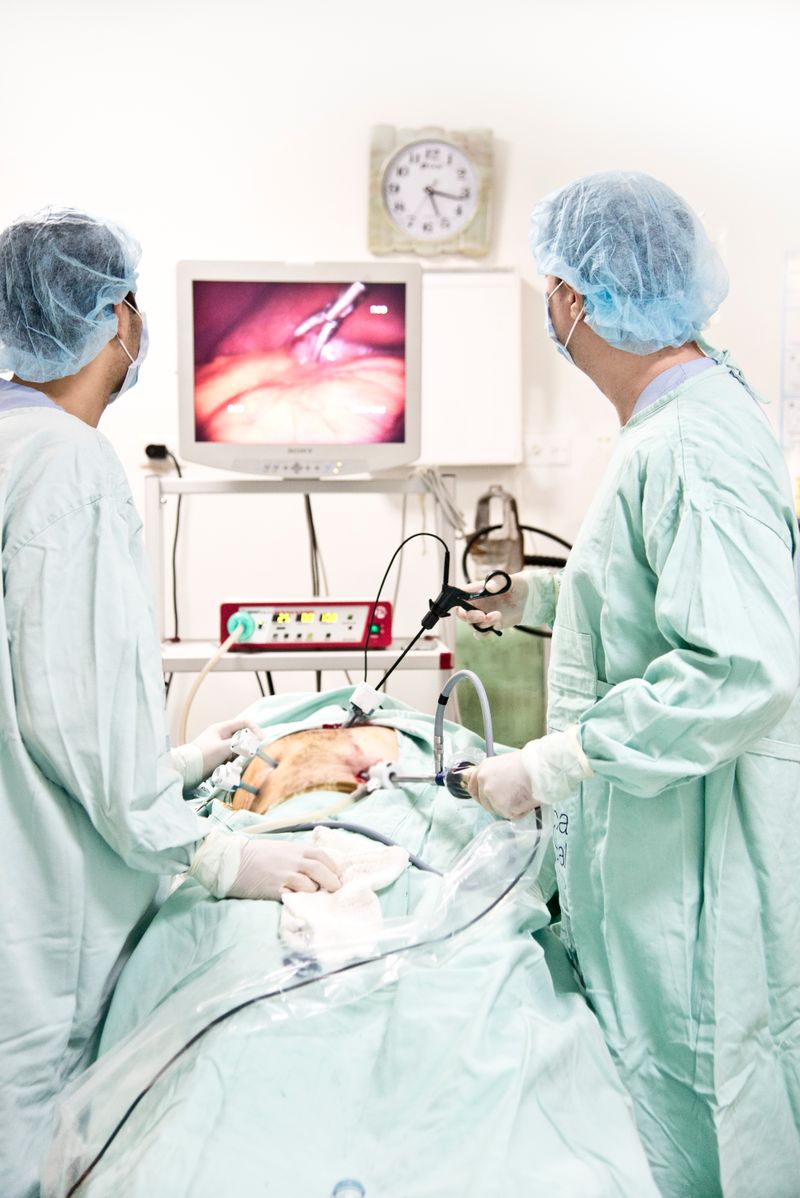 Healthcare professionals performing laparoscopy in operating room
