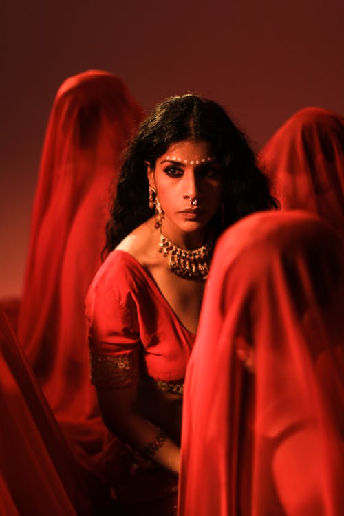 A Woman Surrounded by People Wearing Red Veil