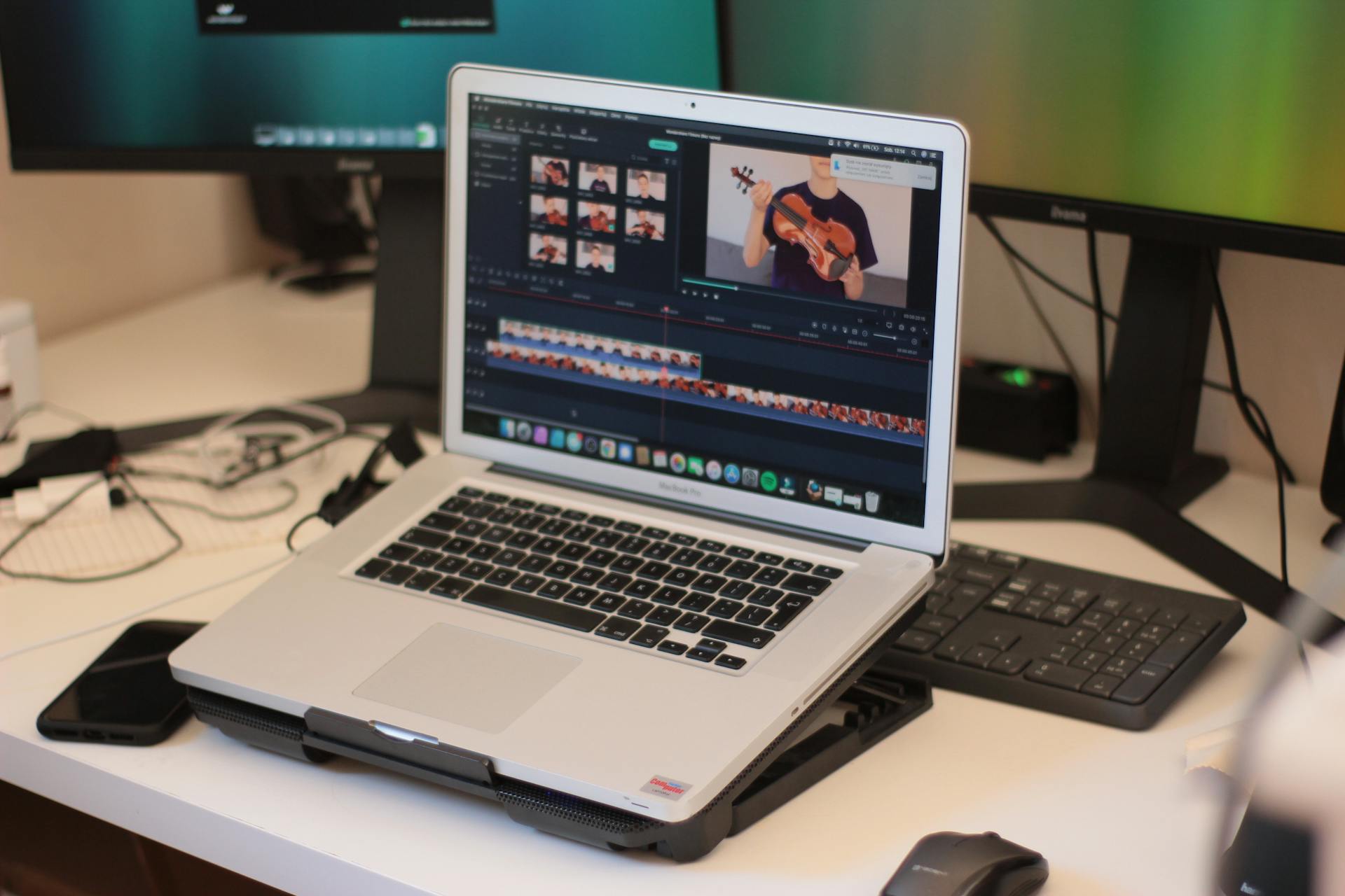 A workspace featuring a laptop editing a video, showcasing modern technology and video editing software.