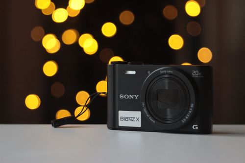 Free A compact camera photographed with beautiful bokeh effects in the background, highlighting its modern aesthetics. Stock Photo