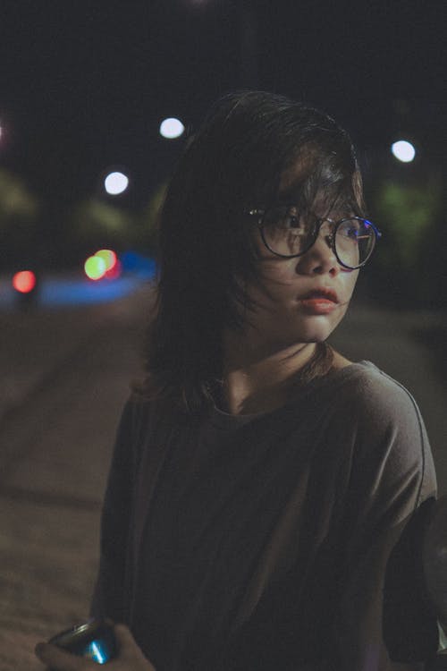 Young Woman in Black Framed Eyeglasses and Black Long Sleeves Shirt Looking Afar